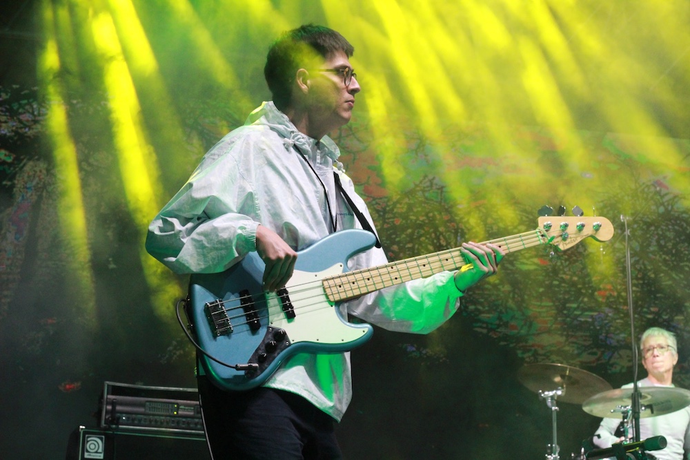 Jorge playing bass on stage with backdrop lighting